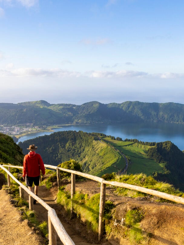 Hiker in a red jacket at the caldera on São Miguel island in the Azores