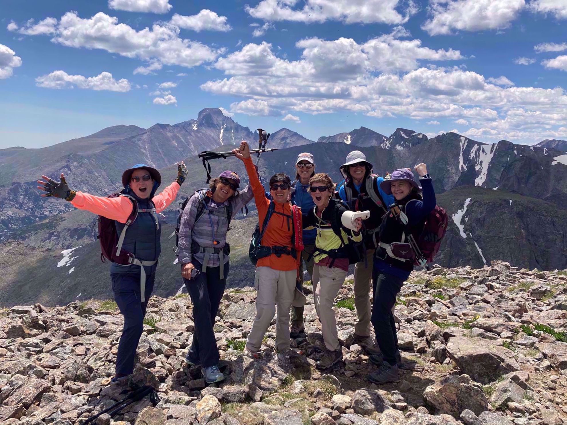 Hikers celebrating on a mountaintop in Rocky Mountain National Park