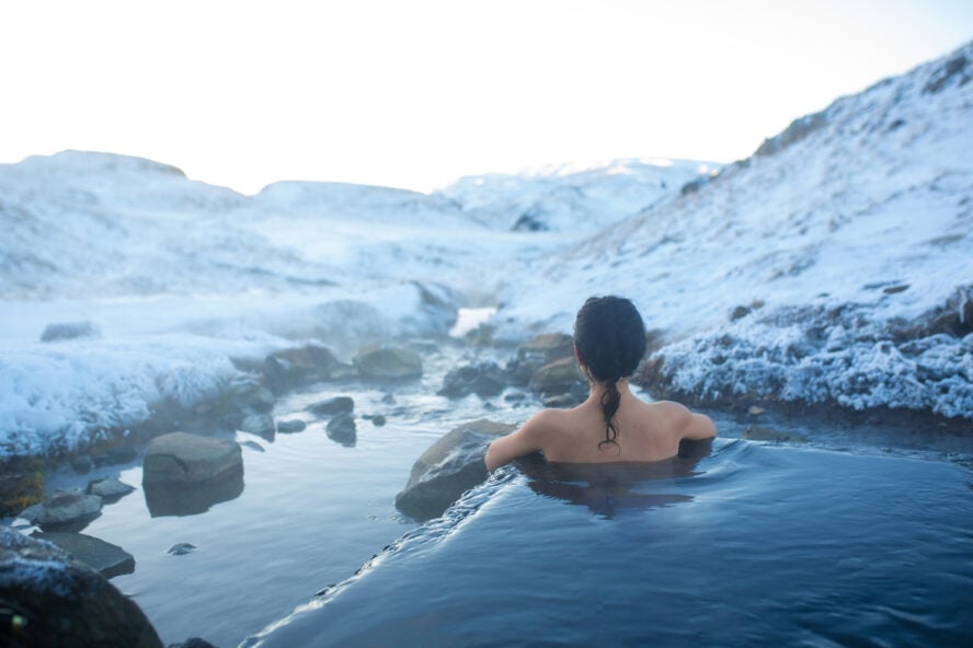 Woman soaking in an Icelandic hot spring in wintertime