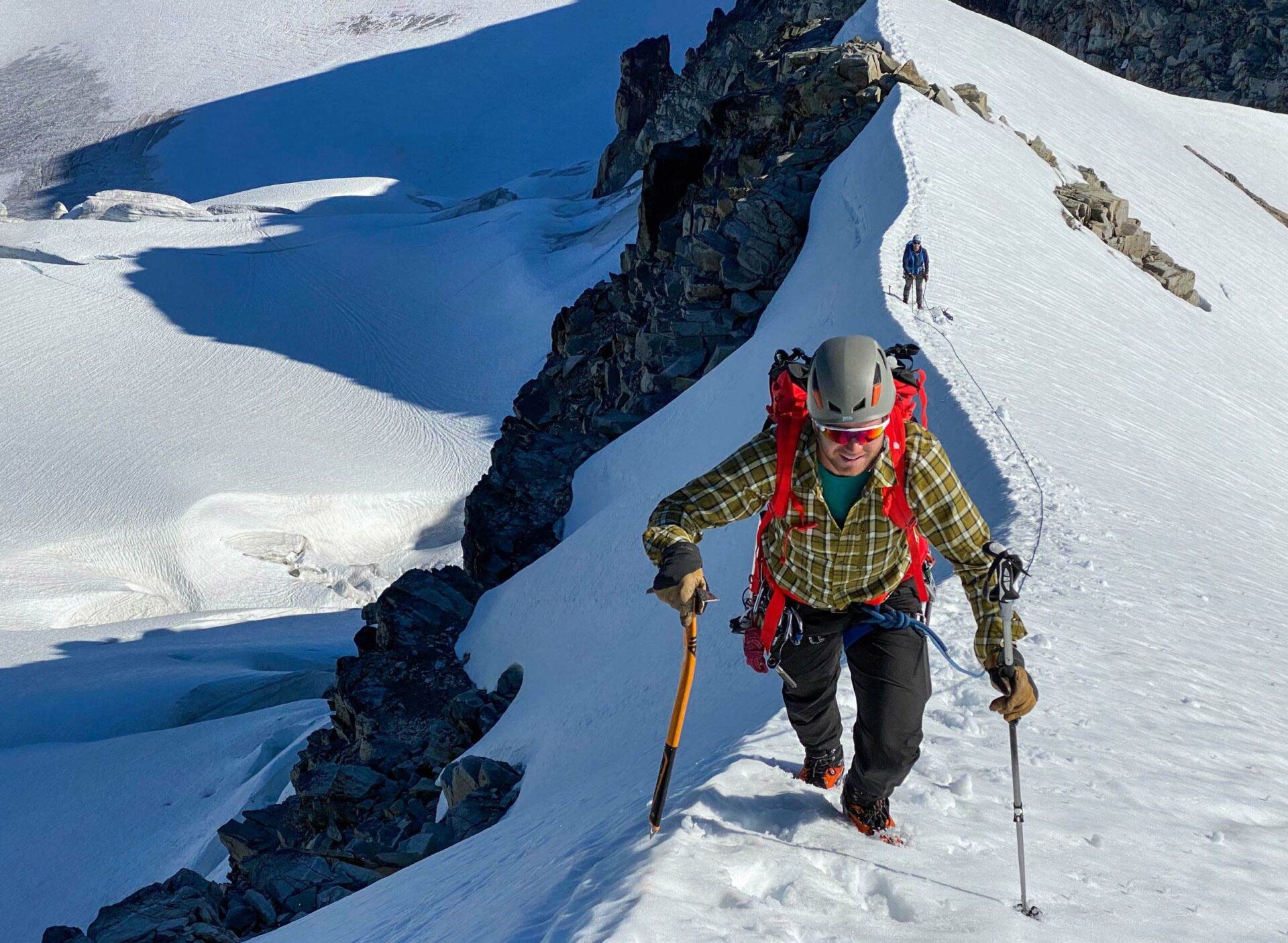 A mountaineer moving along a snowy mountain ridge in British Columbia near Squamish and Whistler.