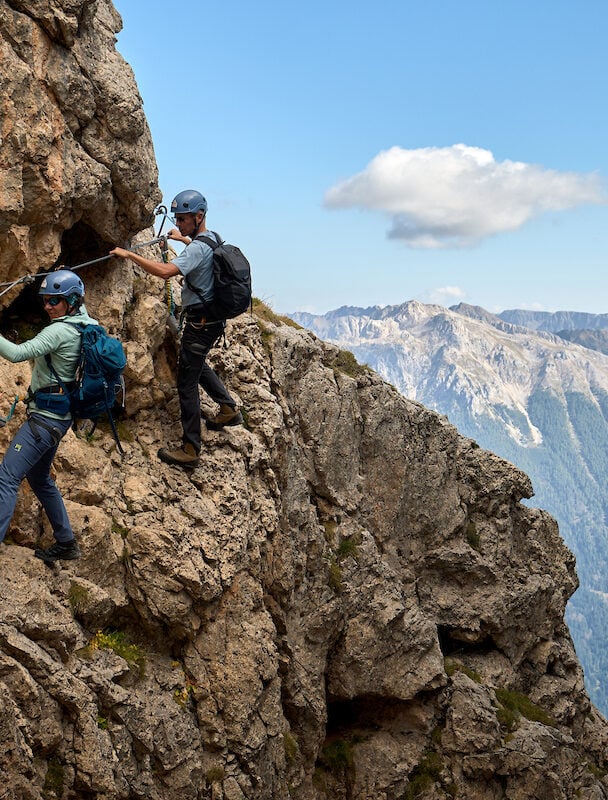 Three climbers valley views Dolomites
